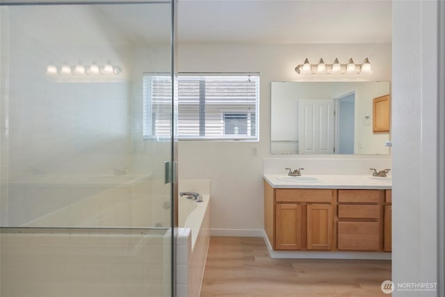 3147 6th Ave NW, Olympia, WA 98502 - bathroom featuring double vanity, wood finished floors, a garden tub, a stall shower, and baseboards