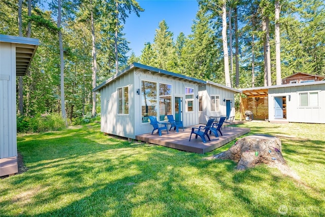 64 Eliza Is, Bellingham, WA 98226 - rear view of house featuring board and batten siding, a deck, an outdoor structure, and a yard