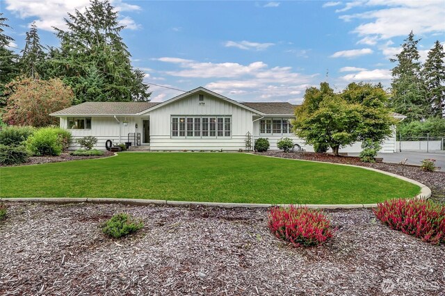 8402 57th Ave E, Puyallup, WA 98371 - rear view of property with board and batten siding and a yard