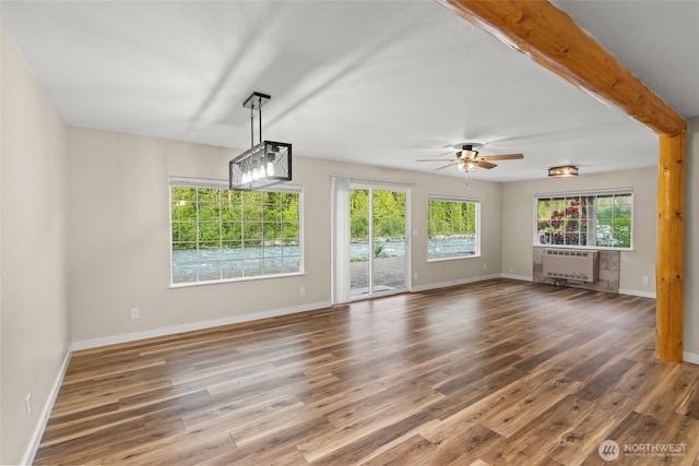 25921 Clear Creek Rd, Darrington, WA 98241 - unfurnished living room featuring radiator, wood finished floors, ceiling fan, and baseboards