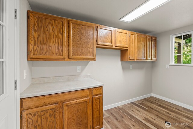 25921 Clear Creek Rd, Darrington, WA 98241 - kitchen with light countertops, light wood-style floors, baseboards, and brown cabinetry