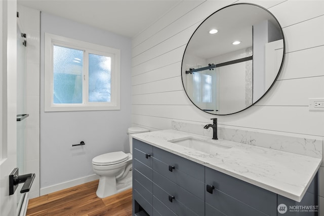 25921 Clear Creek Rd, Darrington, WA 98241 - full bathroom featuring vanity, wood finished floors, toilet, baseboards, and a shower