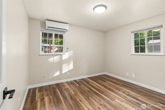 25921 Clear Creek Rd, Darrington, WA 98241 - spare room with a wall unit AC, wood finished floors, and baseboards