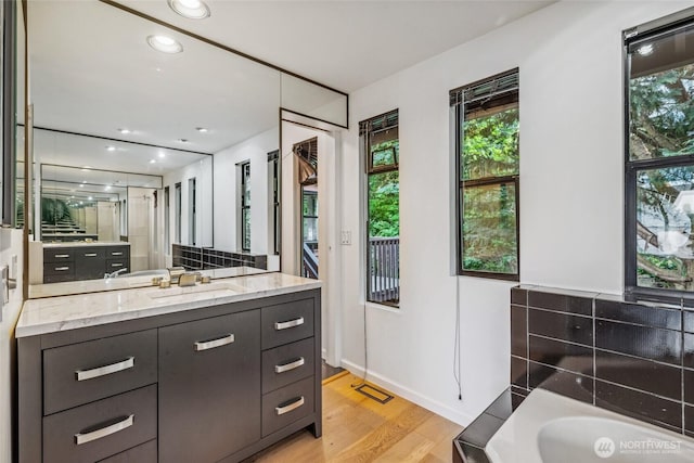 4119 NE 142nd St, Seattle, WA 98125 - full bath featuring vanity, healthy amount of natural light, a garden tub, wood finished floors, and recessed lighting