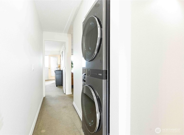 1755 W Sunn Fjord Ln Unit D65, Bremerton, WA 98312 - washroom featuring stacked washer / drying machine, light carpet, and baseboards