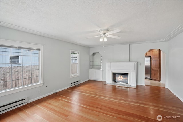 636 20th Ave, Longview, WA 98632 - unfurnished living room with a baseboard heating unit, a ceiling fan, light wood-style floors, a textured ceiling, and a fireplace with flush hearth