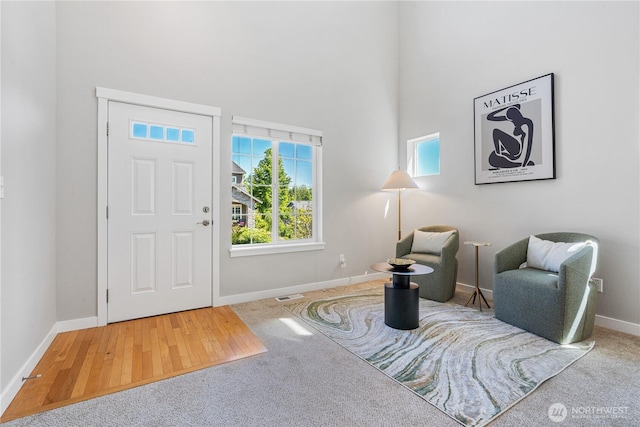 27677 256th Pl SE, Maple Valley, WA 98038 - entryway with baseboards, a high ceiling, carpet floors, and wood finished floors
