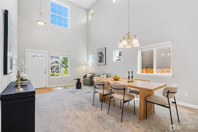 27677 256th Pl SE, Maple Valley, WA 98038 - dining area with a high ceiling, a chandelier, carpet floors, and baseboards