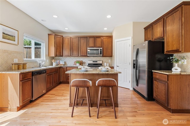 27677 256th Pl SE, Maple Valley, WA 98038 - kitchen featuring stainless steel appliances, a center island, decorative backsplash, light wood-style flooring, and recessed lighting