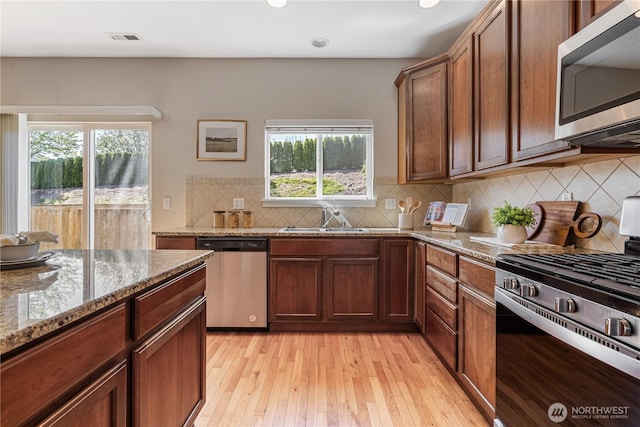 27677 256th Pl SE, Maple Valley, WA 98038 - kitchen featuring appliances with stainless steel finishes, a sink, healthy amount of natural light, light wood-style floors, and recessed lighting