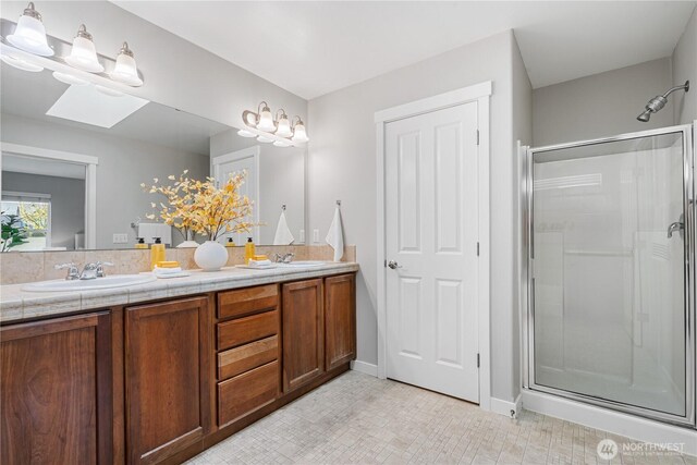 27677 256th Pl SE, Maple Valley, WA 98038 - full bath featuring a stall shower, double vanity, a skylight, and baseboards