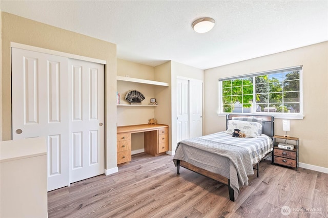 5110 Regan Rd, Cashmere, WA 98815 - bedroom featuring two closets, light wood finished floors, baseboards, and a desk