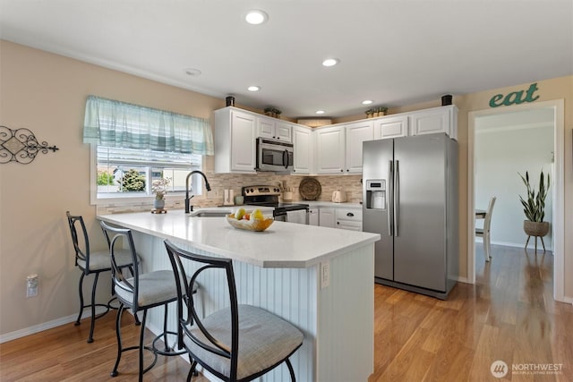 7690 Mcdougall Ave NE, Moses Lake, WA 98837 - kitchen with stainless steel appliances, a peninsula, a sink, white cabinetry, and recessed lighting