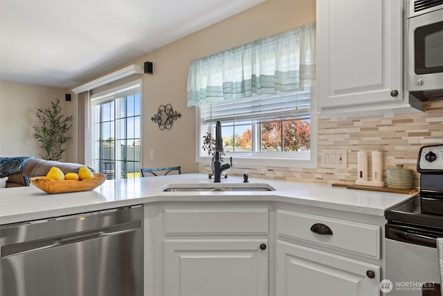 7690 Mcdougall Ave NE, Moses Lake, WA 98837 - kitchen featuring stainless steel appliances, a sink, tasteful backsplash, white cabinets, and light stone counters