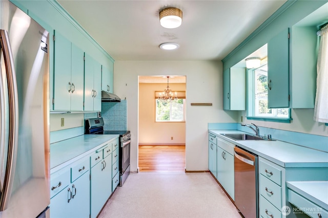 434 T St, Port Townsend, WA 98368 - kitchen featuring appliances with stainless steel finishes, a sink, under cabinet range hood, light countertops, and a chandelier