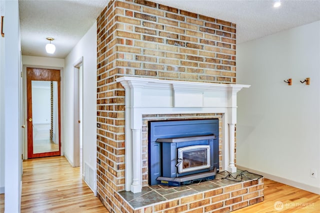 434 T St, Port Townsend, WA 98368 - detailed view of a textured ceiling, wood finished floors, baseboards, and a wood stove