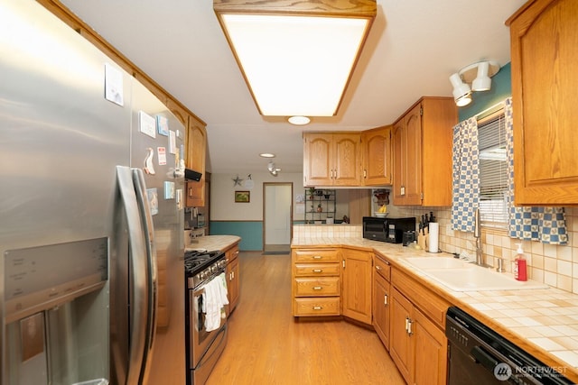 10930 38th Dr SE, Everett, WA 98208 - kitchen featuring black appliances, tile counters, a sink, and backsplash