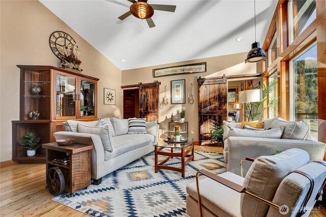 76 Thompson Point Rd, Port Angeles, WA 98363 - living area with ceiling fan, a barn door, light wood-style floors, and high vaulted ceiling