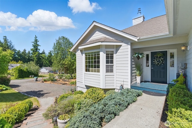 37401 Olympic View Rd NE, Hansville, WA 98340 - property entrance with a shingled roof and a chimney