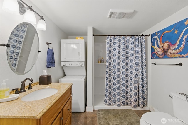 37401 Olympic View Rd NE, Hansville, WA 98340 - bathroom with stacked washing machine and dryer, toilet, vanity, and a shower with shower curtain