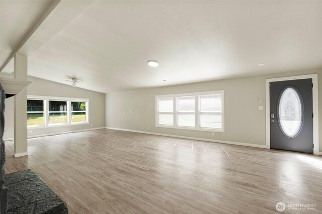 20119 120th Ave E, Graham, WA 98338 - unfurnished living room with healthy amount of natural light, light wood-style flooring, baseboards, and vaulted ceiling