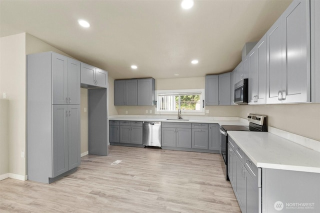 20119 120th Ave E, Graham, WA 98338 - kitchen with stainless steel appliances, a sink, gray cabinetry, light wood finished floors, and recessed lighting