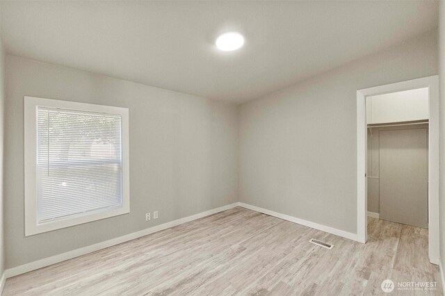 20119 120th Ave E, Graham, WA 98338 - unfurnished bedroom featuring wood finished floors, a walk in closet, baseboards, and a closet