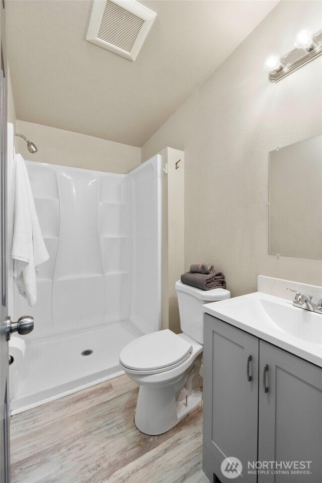 20119 120th Ave E, Graham, WA 98338 - bathroom featuring vanity, toilet, wood finished floors, a shower, and vaulted ceiling