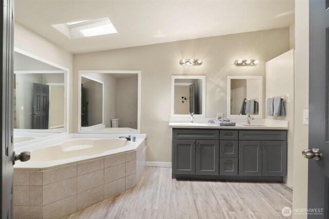 20119 120th Ave E, Graham, WA 98338 - full bathroom with a skylight, a bath, double vanity, and toilet