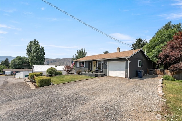 1598 Tedford St SE, East Wenatchee, WA 98802 - ranch-style home with a garage, gravel driveway, and a chimney