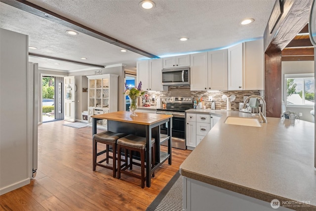 1598 Tedford St SE, East Wenatchee, WA 98802 - kitchen with appliances with stainless steel finishes, a textured ceiling, tasteful backsplash, butcher block counters, and recessed lighting