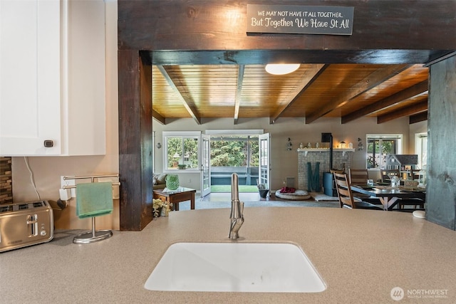 1598 Tedford St SE, East Wenatchee, WA 98802 - kitchen featuring a wood ceiling with exposed beams, a fireplace, white cabinets, and open floor plan