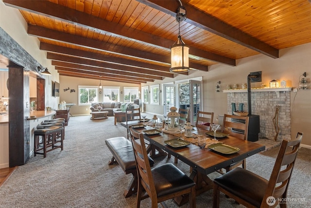 1598 Tedford St SE, East Wenatchee, WA 98802 - dining area featuring a wood stove, a wood ceiling with exposed beams, and carpet floors