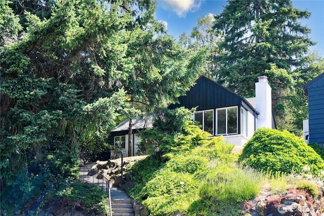 2874 30th Ave W, Seattle, WA 99819 - view of home's exterior with a chimney, board and batten siding, and stairway