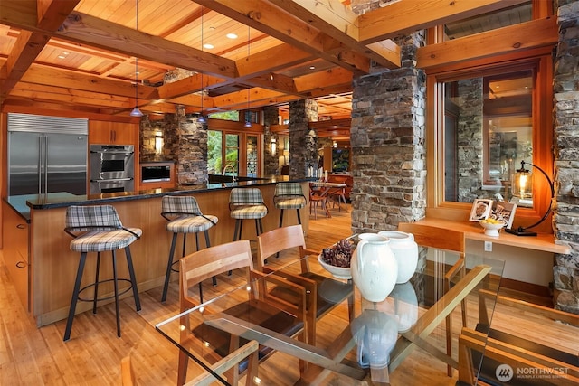 15910 Uplands Way SE, North Bend, WA 98045 - indoor bar featuring appliances with stainless steel finishes, light wood-style floors, wood ceiling with exposed beams, and ornate columns