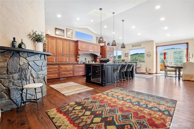 127 Bella Ln, Manson, WA 98831 - kitchen featuring a kitchen island with sink, dark wood finished floors, high vaulted ceiling, a breakfast bar area, and plenty of natural light