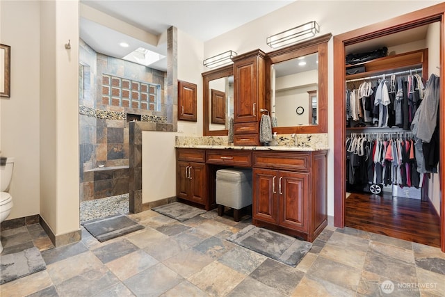 127 Bella Ln, Manson, WA 98831 - full bath with stone tile floors, toilet, double vanity, walk in shower, and recessed lighting