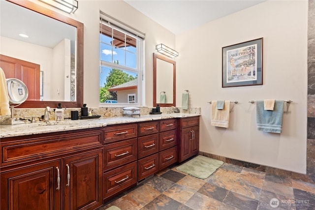 127 Bella Ln, Manson, WA 98831 - full bathroom featuring double vanity, stone finish flooring, and baseboards
