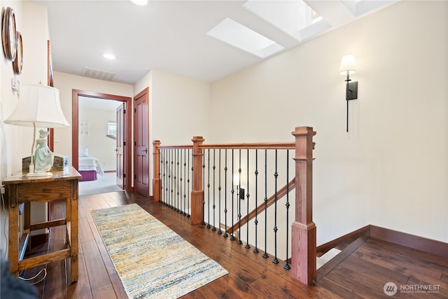 127 Bella Ln, Manson, WA 98831 - corridor featuring a skylight, dark wood-style flooring, recessed lighting, an upstairs landing, and baseboards