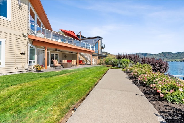 127 Bella Ln, Manson, WA 98831 - view of grassy yard with an outdoor hangout area, ceiling fan, a balcony, a water and mountain view, and a patio area