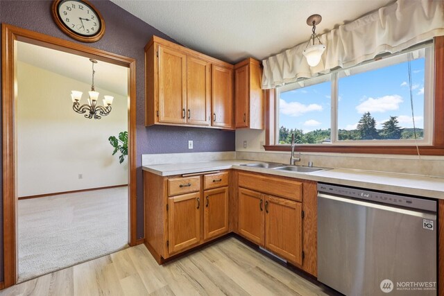 13820 Logez Ct SW, Olympia, WA 98512 - kitchen with stainless steel dishwasher, a sink, light countertops, a chandelier, and light wood finished floors