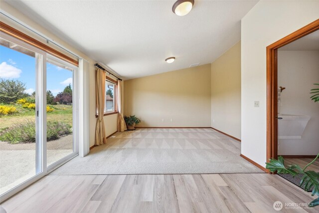 13820 Logez Ct SW, Olympia, WA 98512 - spare room with lofted ceiling, light wood-style floors, plenty of natural light, baseboards, and light carpet