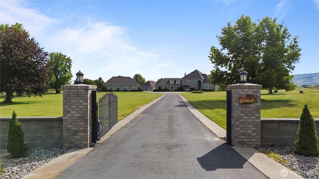 1702 Jb George Rd, Walla Walla, WA 99362 - view of asphalt driveway featuring street lights, a gate, a residential view, and a gated entry