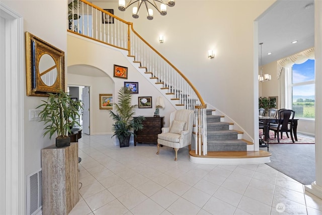 1702 Jb George Rd, Walla Walla, WA 99362 - staircase featuring a chandelier, tile patterned flooring, a high ceiling, arched walkways, and baseboards