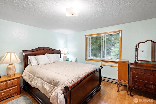 4119 Big Beef Xing NW, Bremerton, WA 98312 - bedroom featuring wood finished floors, a textured ceiling, and a baseboard heating unit