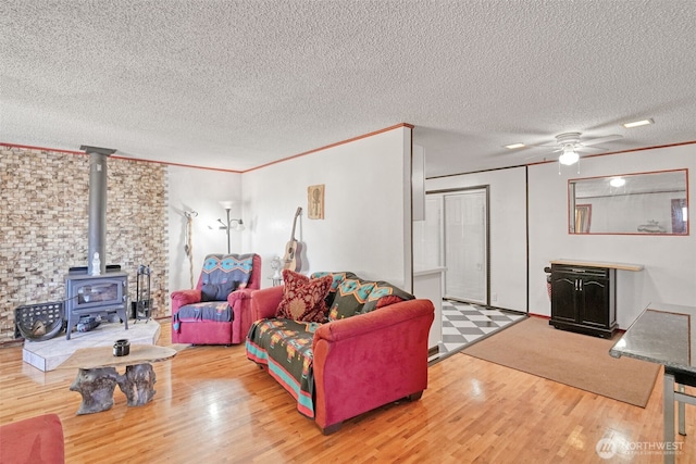 6965E E E, Tacoma, WA 98404 - living area with a wood stove, a textured ceiling, wood finished floors, ceiling fan, and crown molding