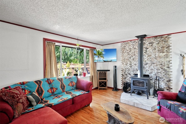 6965E E E, Tacoma, WA 98404 - living room featuring a wood stove, a textured ceiling, wood finished floors, and ornamental molding