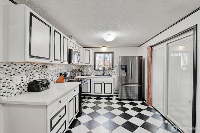 6965E E E, Tacoma, WA 98404 - kitchen with appliances with stainless steel finishes, dark floors, a sink, light countertops, and tasteful backsplash