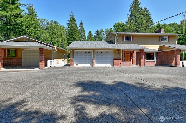 26025 Tronson Rd, Arlington, WA 98223 - view of front of property featuring an attached garage, brick siding, a chimney, and driveway