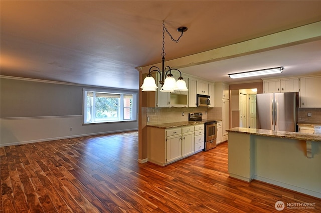 26025 Tronson Rd, Arlington, WA 98223 - kitchen featuring appliances with stainless steel finishes, decorative backsplash, dark wood-type flooring, and a chandelier